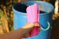 Women& x27;s hand holding pink plastic tube To throw away the trash Concepts of using plastic tubes to reduce global warming