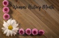 Womens History Month on wooden board with pink flower border flat lay Royalty Free Stock Photo