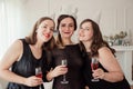 Womens party. Girlfriends girls in black dresses kiss the birthday girl. Glasses with pink champagne in hands Royalty Free Stock Photo