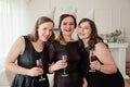 Womens party. Girlfriends girls in black dresses kiss the birthday girl. Glasses with pink champagne in hands Royalty Free Stock Photo