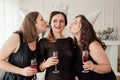 Womens party. Girlfriends girls in black dresses kiss the birthday girl. Glasses with pink champagne in hands Royalty Free Stock Photo