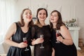 Womens party. Girlfriends girls in black dresses with wine glasses in hands Royalty Free Stock Photo