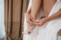 Womens sexy legs. Woman buttons her high heel shoes. Beautiful woman legs wearing dress with high heel shoes. Royalty Free Stock Photo