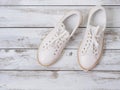 Womens shoes white sneakers on wooden background. Spring summer collection. Fashion concept. Flat lay