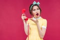 Wondered beautiful pinup girl holding red receiverand talking on Royalty Free Stock Photo