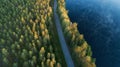 Wonderful aerial nature landscape. Road between forest and misty lake at sunrise time