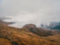 Wonderful alpine scenery with great plateau and mountains in dense low clouds. Atmospheric highlands landscape with mountain tops Royalty Free Stock Photo