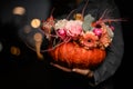 wonderful bouquet of flowers in pumpkin on female hand. Decoration for thanksgiving day and halloween Royalty Free Stock Photo