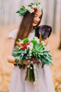 Wonderful bride with wedding bouguet happily smiling. Autumn forest on background