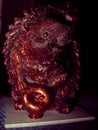 A wonderful chocolate hedgehog figurine carrying chocolate apples. Culinary creativity. Edible sculpture on a dark background