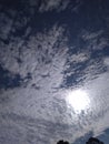 A wonderful close up of an exceptional view of an delightful pattern of white clouds in dark blue sky with shining sun