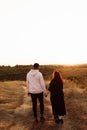 Wonderful couple walking at the field, African American man holding hands lovely white woman, attractive husband with