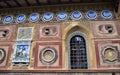 Wonderful element, of a richly decorated wall, with a window on the right side and in the other a colored coat of arms, at villa S Royalty Free Stock Photo