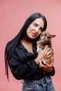 Wonderful european female model chilling in studio with puppy. Indoor portrait of debonair girl enjoying photoshoot with her cute