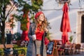 Wonderful female model in gray clothes walking down the street with cup of coffee. Glamorous slim girl in beret looking