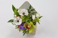 Wonderful floral arrangement of fresh flowers in a box in the form of an envelope on a light background.