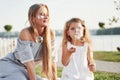 A wonderful girl child makes bubbles with her mom in the park Royalty Free Stock Photo