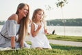 A wonderful girl child makes bubbles with her mom in the park. Royalty Free Stock Photo