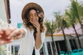 Wonderful girl with curly hairstyle taking picture of herself on sky background. Portrait of ecstat