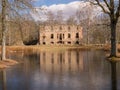 Wonderful landscape with old manor ruins, early spring, beautiful blue sky with white clouds, small pond with beautiful