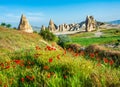 Wonderful landscape with view at fairy chimneys and with flowering poppies in Cappadocia, Anatolia, Turkey. Volcanic mountains in Royalty Free Stock Photo