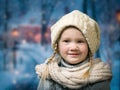 Wonderful little girl under falling snow, snowflakes