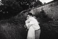 A wonderful love story. Young couple walking around the old wall of castle. Black and white Royalty Free Stock Photo