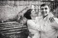 A wonderful love story. Young couple walking around the old wall of castle. Black and white Royalty Free Stock Photo