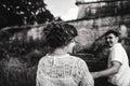 A wonderful love story. Young couple walking around the old wall of castle. Black and white Royalty Free Stock Photo