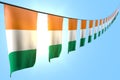 wonderful many Cote d Ivoire flags or banners hangs diagonal on rope on blue sky background with soft focus - any occasion flag 3d