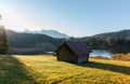 Wonderful misty morning with blue sky over the mountain valley.  View over Geroldsee with wooden hut and Karwendel mountains at Royalty Free Stock Photo