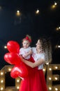 A wonderful mother and baby surrounded by balloons in the shape of a heart