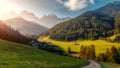 Wonderful nature Landscape. The greenery hills and small village with Alpine Mountain in background Val di Funes