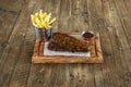 A wonderful plate of grilled pork ribs with barbecue sauce on the surface, inside a small container and another metal container