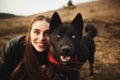 A wonderful portrait of a girl and her dog with colorful eyes. Friends are posing on the shore of the lake