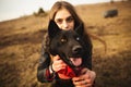 A wonderful portrait of a girl and her dog with colorful eyes. Friends are posing on the shore of the lake