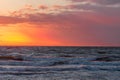 Wonderful red sunset reflections on the crashing sea waves