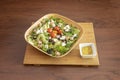 wonderful salad served in a bamboo wood bowl with jam tacos, red and yellow cherry tomatoes, chopped fresh cheese, slices of black Royalty Free Stock Photo