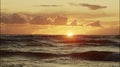A wonderful seascape with the sun going beyond the horizon and ocean waves. An ideal sunset landscape with a sky on Royalty Free Stock Photo