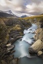 Wonderful sun lit autumn landscape with wild river raging down