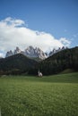 Sunny Landscape of Dolomite Alps with St Johann Church and mountains in the background Royalty Free Stock Photo