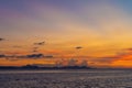 Wonderful sunset landscape on the seashore, colors of the sunset sky and silhouette of island in the water. incredible tropical