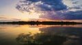 Wonderful sunset panorama over the city horizon with reflection on the calm lake water in a silent summer evening Royalty Free Stock Photo