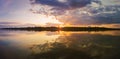 Wonderful sunset panorama over the city horizon with reflection on the calm lake water in a silent summer evening Royalty Free Stock Photo