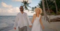 Wonderful tropical ocean beach in the evening, young couple walking hand in hand near the water