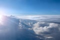 Wonderful view from window of plane in morning sun over clouds. Unusual clouds illuminated by rays of sun. Beautiful white clouds