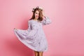 Wonderful white girl in vintage purple dress posing in studio. Indoor portrait of refined young lady in circlet of Royalty Free Stock Photo