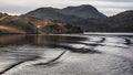 Wonderful Winter landscape image viewed from boat on Ullswater in Lake District with unusual water ripple wake movements Royalty Free Stock Photo