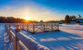 Winter sunrise over a snow-covered lake and a wooden pier Royalty Free Stock Photo