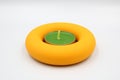 wonderful yellow candle holder with green candle. Round stand with a lighted candle Royalty Free Stock Photo